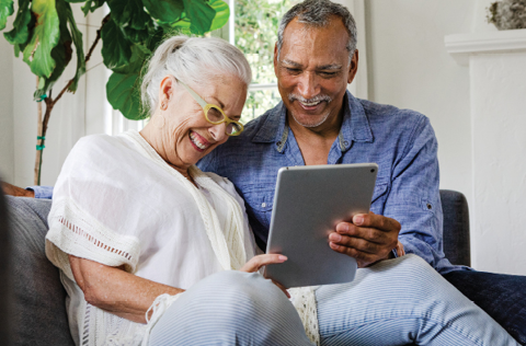 Man and woman looking at ipad and laughing